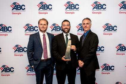 three men in suits with award