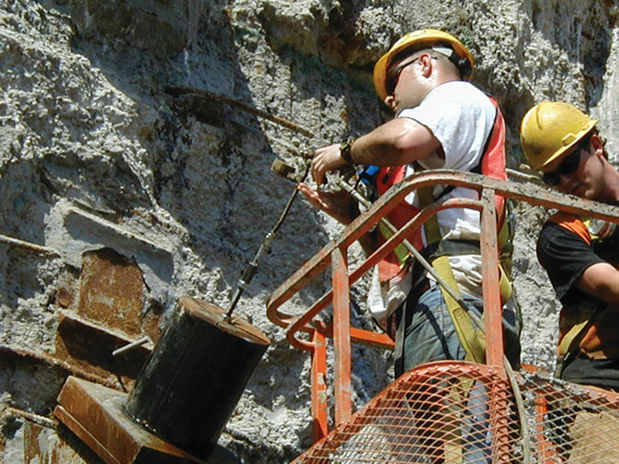 man grouting around anchor of trade center foundation