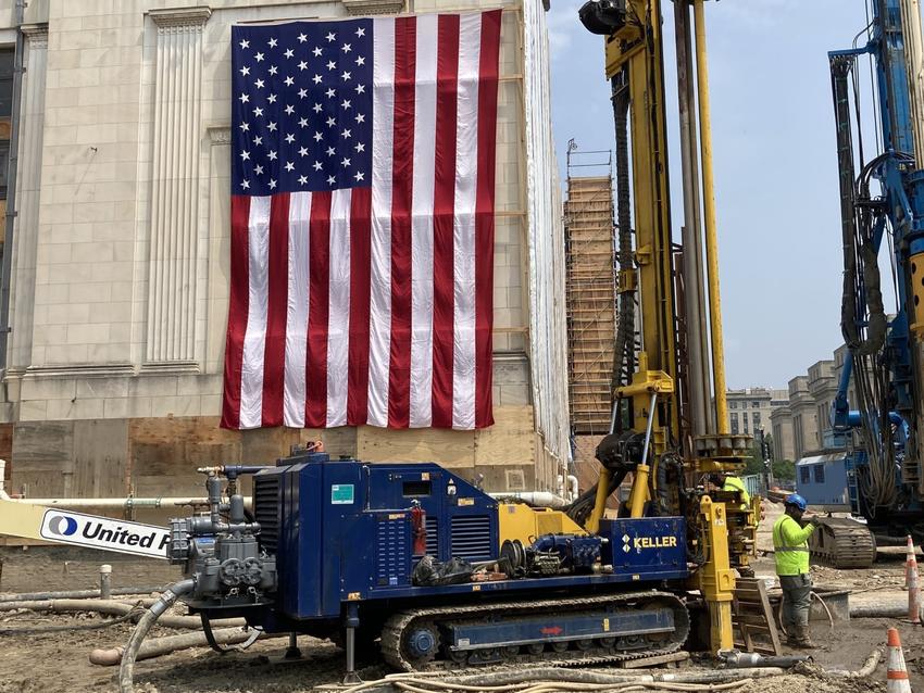 drill rig next to historical building with American flag